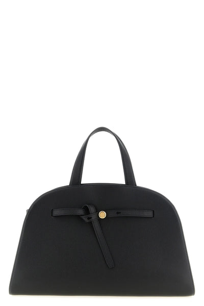 the romy tory burch trunk bag stands out for its structured and rounded silhouet