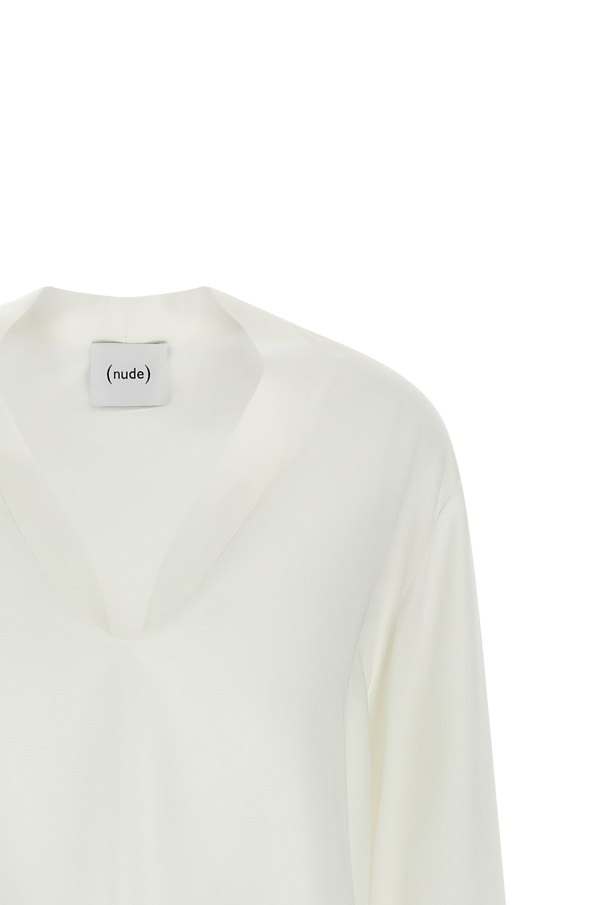 the nude blouse is distinguished by a fluid and deconstructed silhouette
