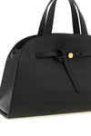 the romy tory burch trunk bag stands out for its structured and rounded silhouet