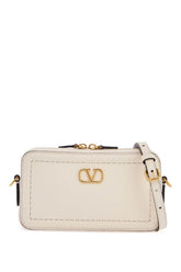 mini camera case in ivory leather with adjustable strap and golden details