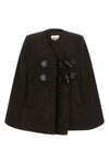the ganni cape redefines the volumes of the outerwear through a flared and envel