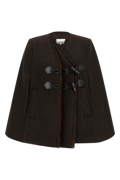 the ganni cape redefines the volumes of the outerwear through a flared and envel