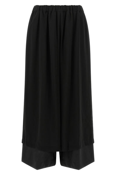 the comme des garcons trousers are distinguished by a fluid and voluminous silho