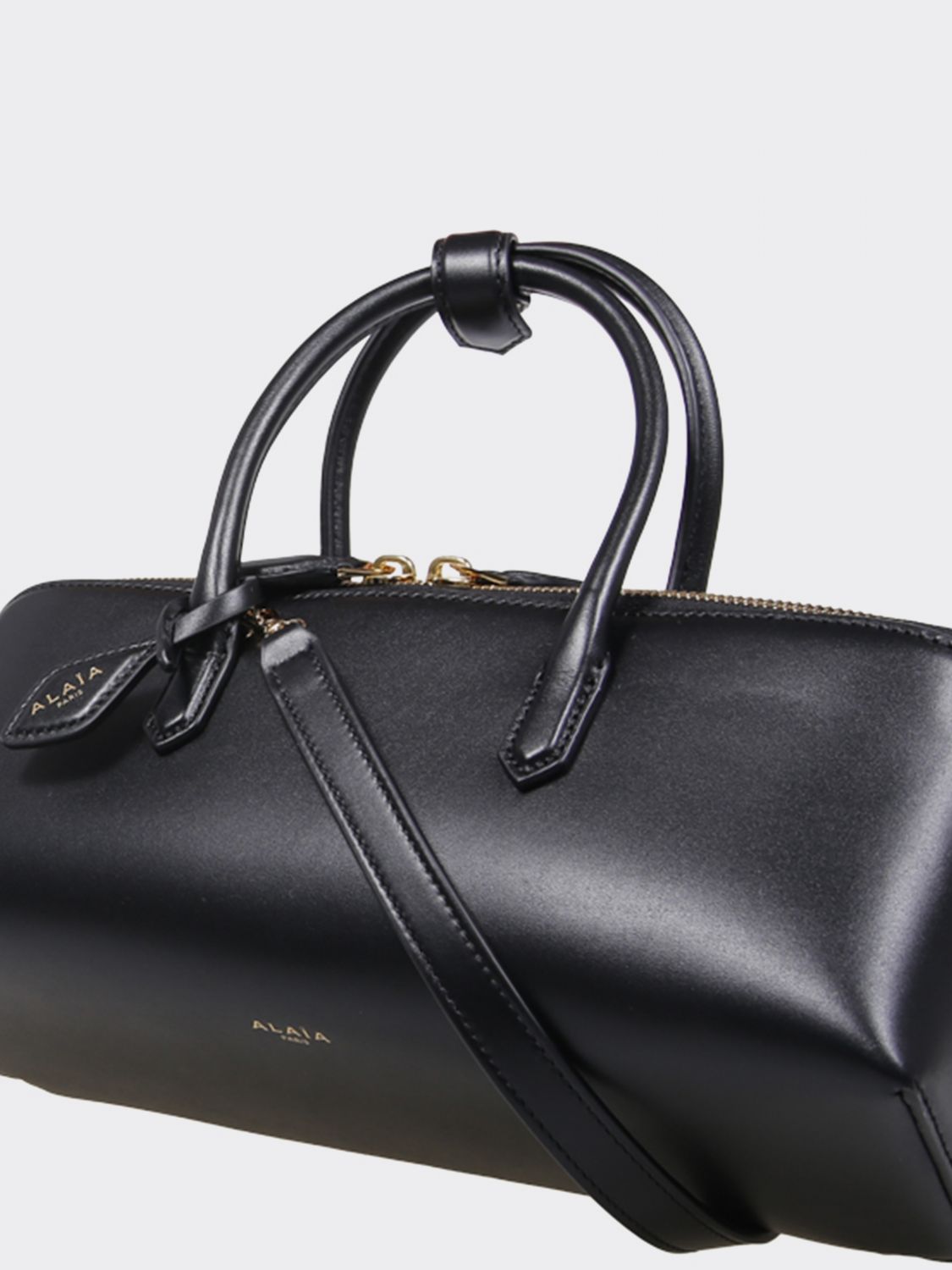 small leather handbag with double tubular handle and logo charm